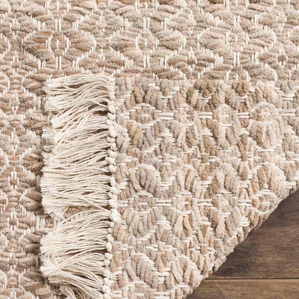 A folded edge reveals the rug's intricate woven underside and soft ivory fringe