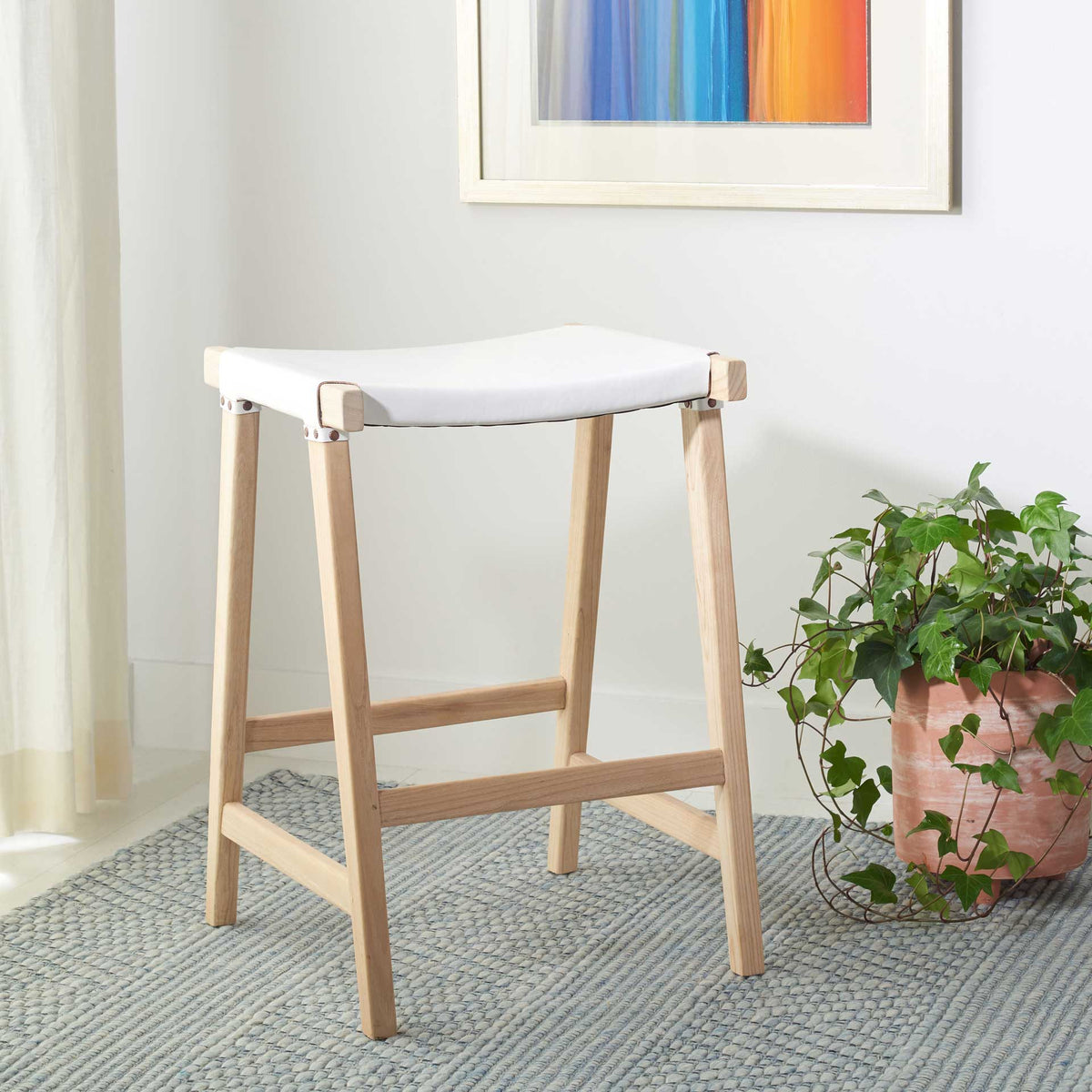 White leather and light wood give this counter stool a fresh, airy feel with practical footrest support