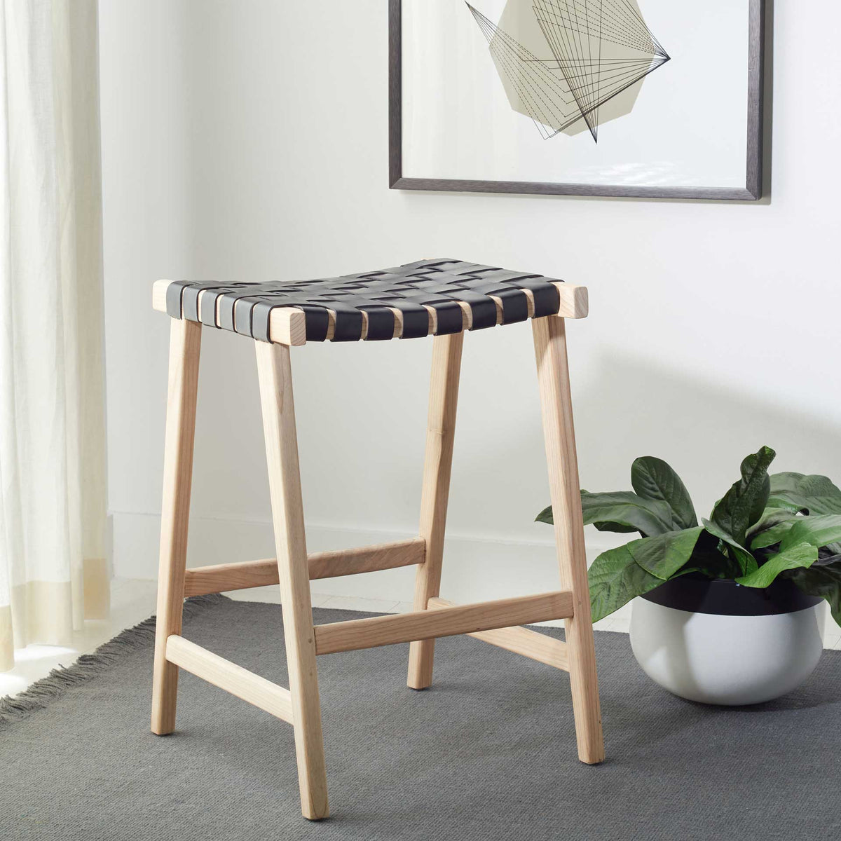A black woven seat sets off the blond wood frame for a fresh, relaxed living space accent