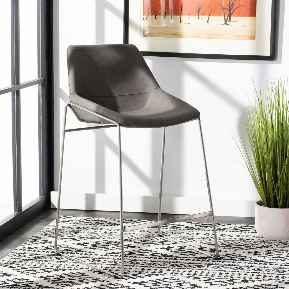 Soft gray upholstery and a sleek silver frame add a contemporary accent to a bright room.