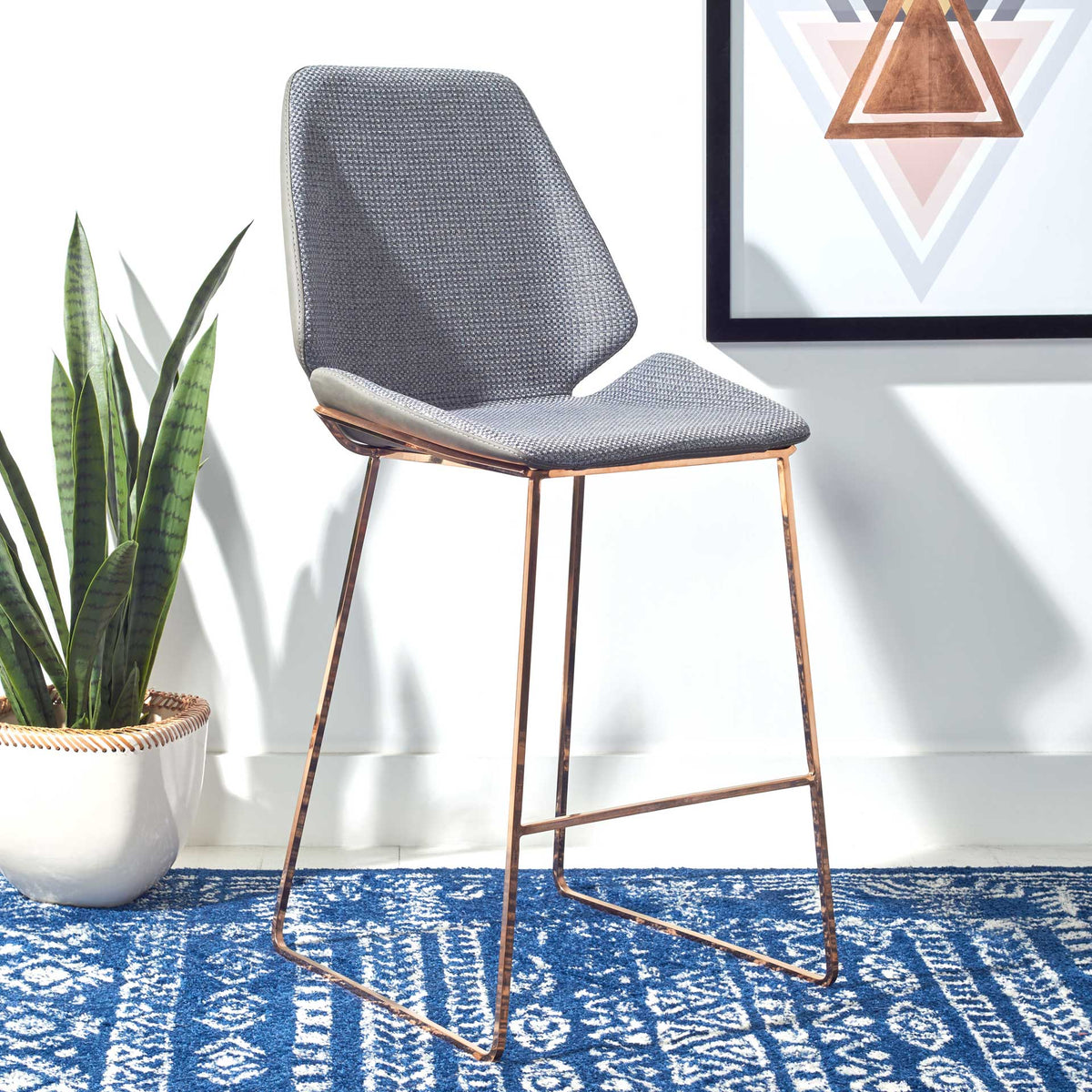 The shaped gray back and open metal base create an airy silhouette with a built-in footrest.