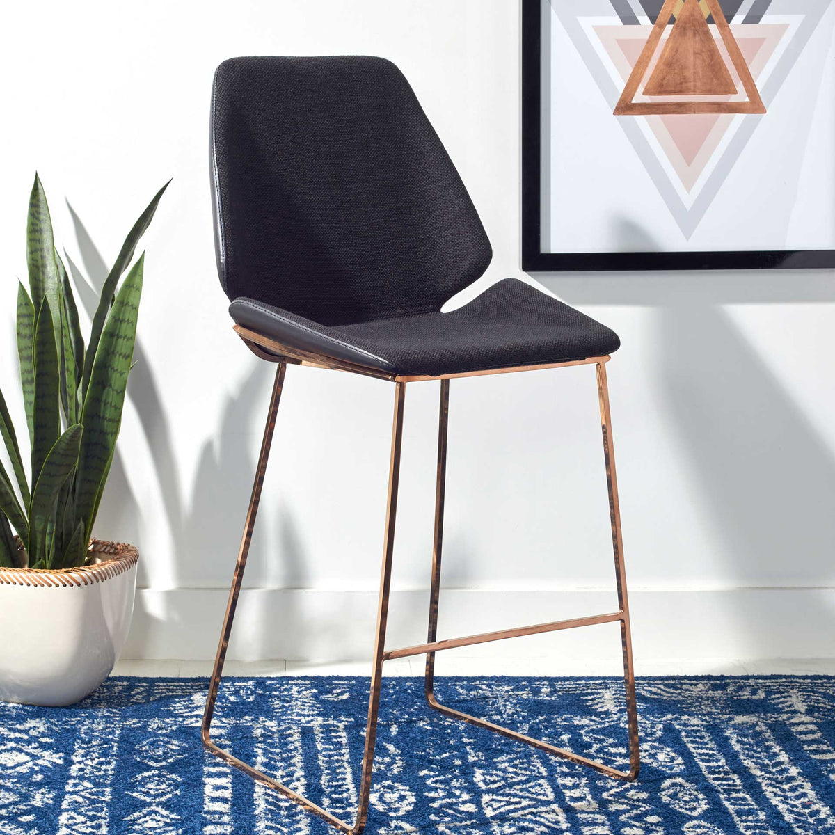 Raised seat sides and a slender gold-tone footrest give this black stool a polished look.