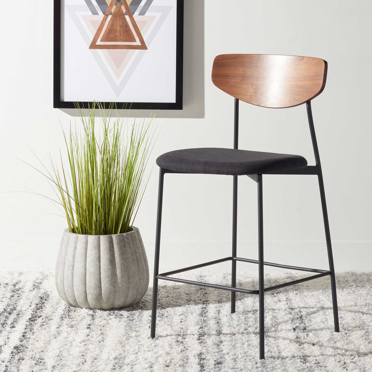 Curved walnut backrest and dark upholstered seat warm up this slender black counter stool