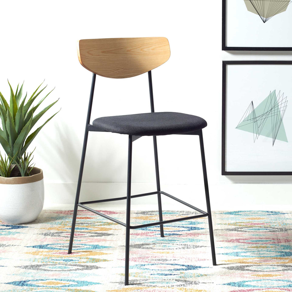 Oak backrest and black upholstered seat bring mid-century appeal to a slim counter stool