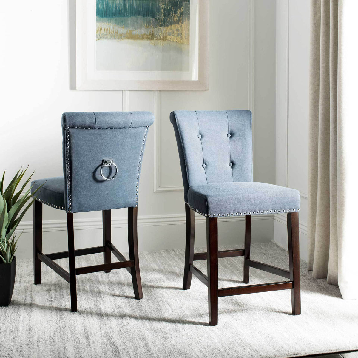 Navy linen counter stools pair button-tufted fronts with chrome back rings and espresso wood legs.
