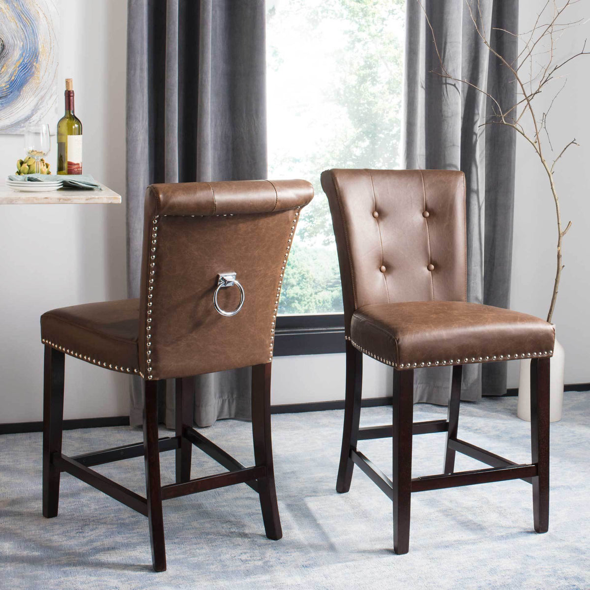 Brown faux leather counter stools pair plush tufting with a chrome back ring and espresso wood footrests.