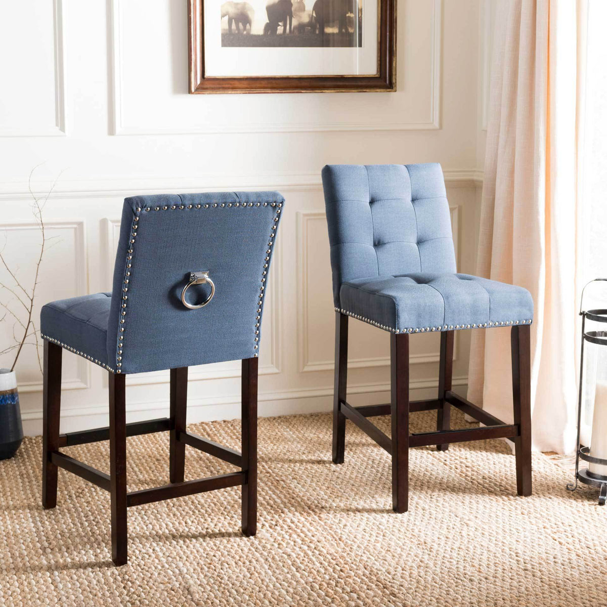 A pair of navy counter stools shows tufted seats and chrome ring details on their backs