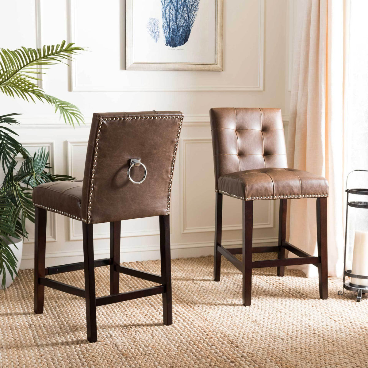 A pair of brown counter stools shows tufted seats, chrome back rings and dark wood footrests