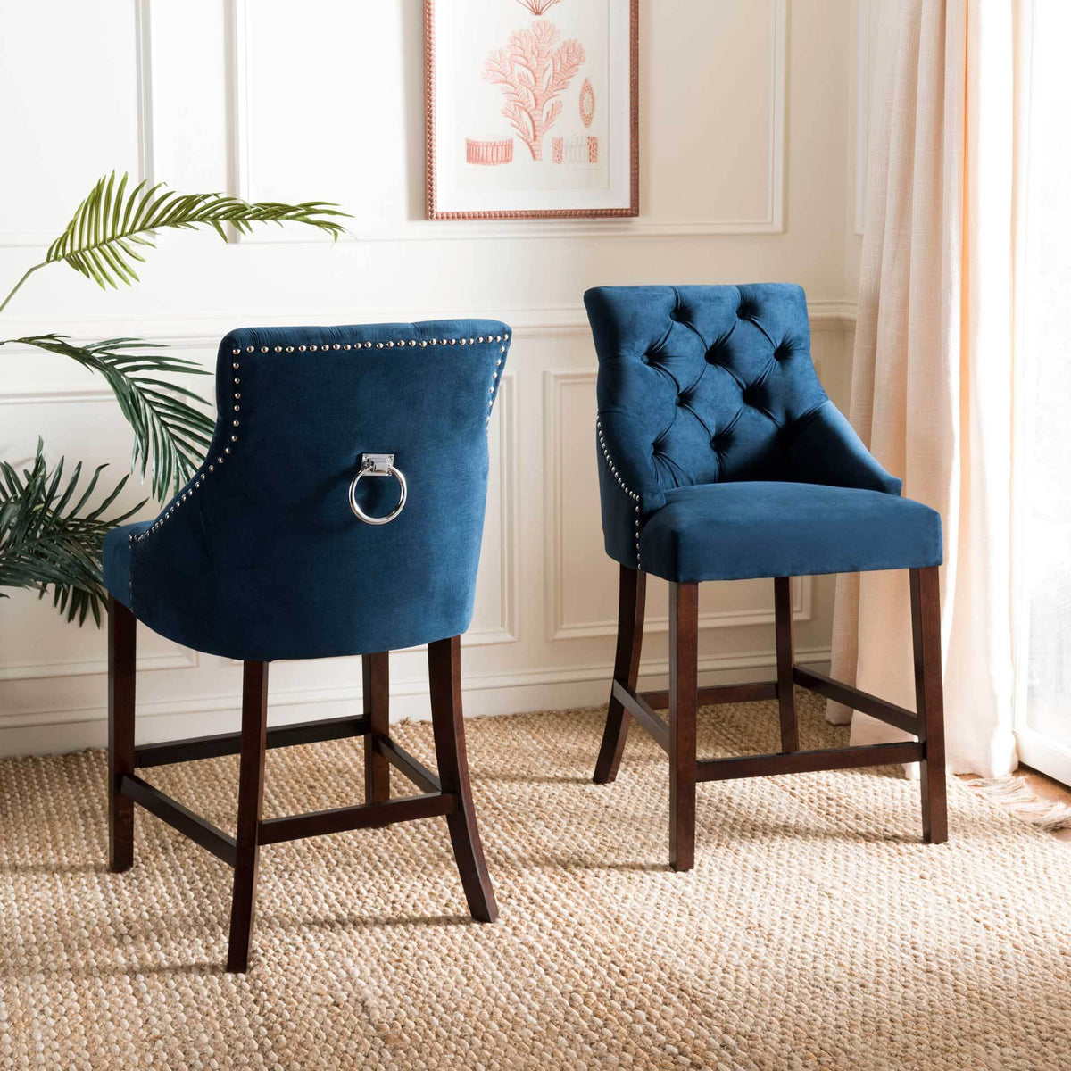Navy velvet counter stools bring tufted texture, chrome ring accents, and warm wood frames to a bright room.