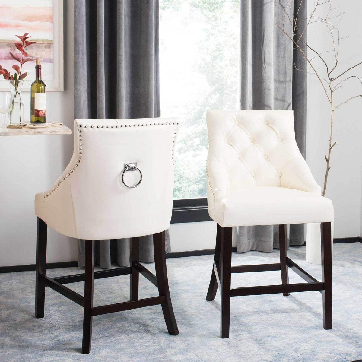 White tufted counter stools brighten a dining nook with polished chrome rings and dark wood frames.
