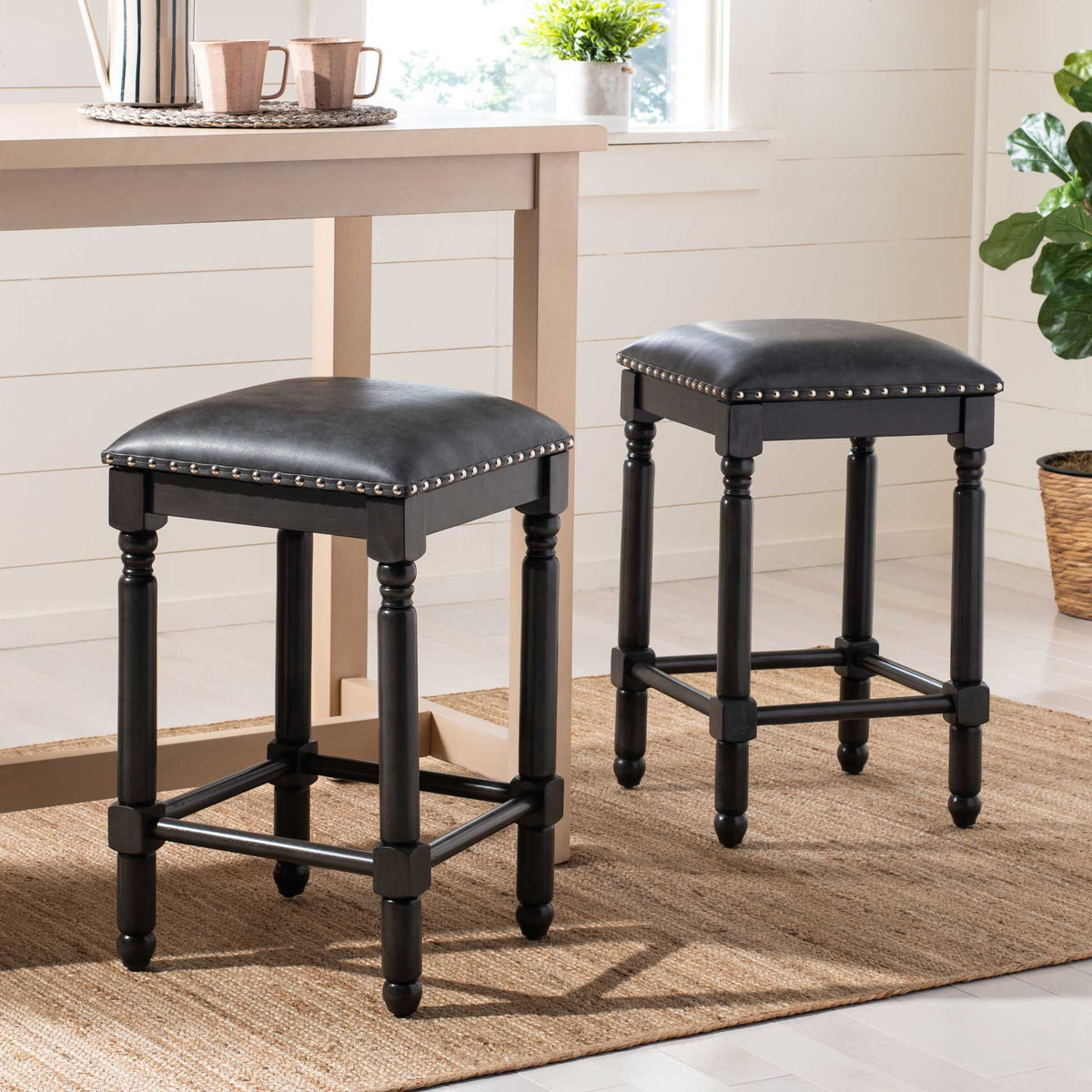 Matching gray counter stools bring padded comfort and traditional turned legs to a bright dining area