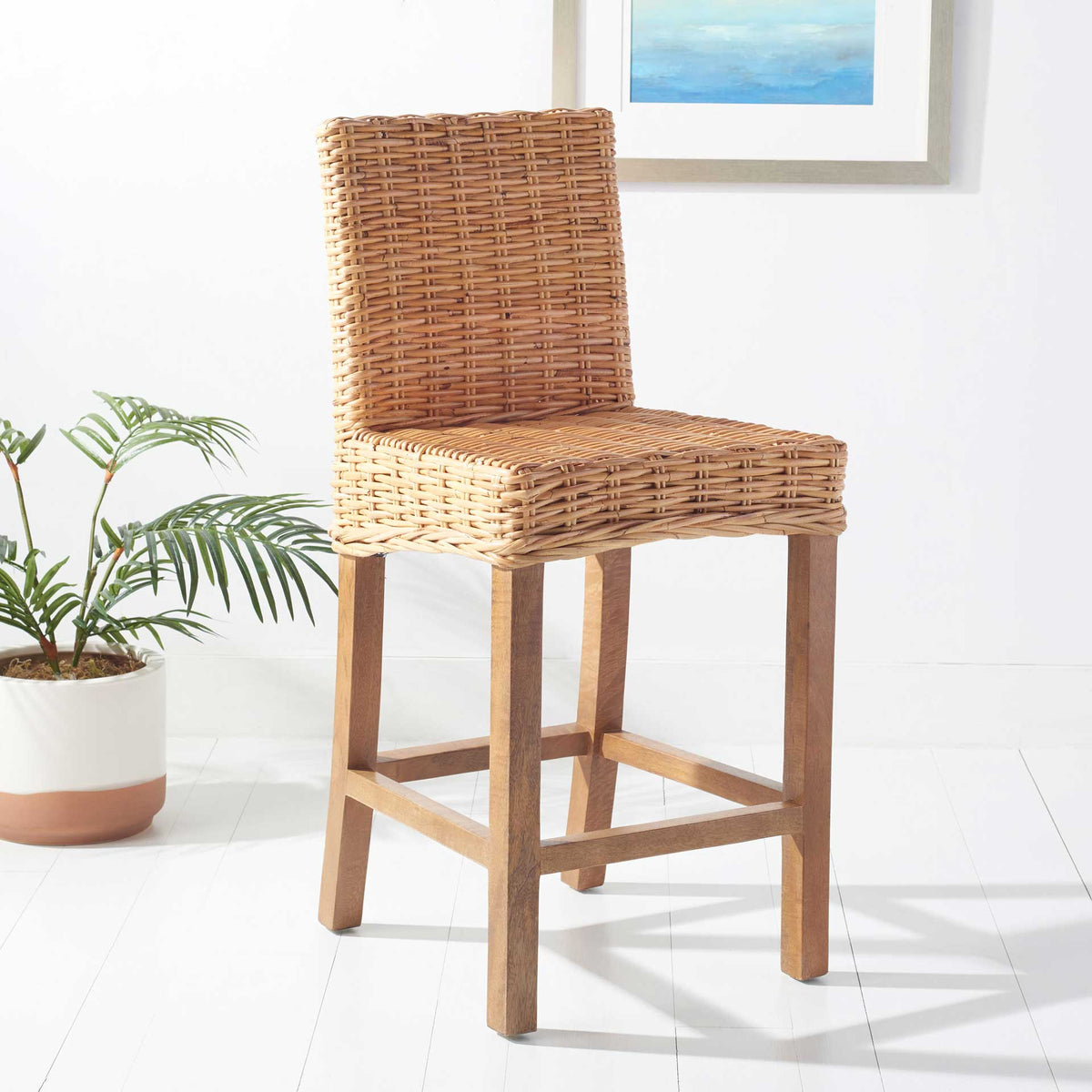 Golden wicker counter stool lends casual coastal charm to a light-filled interior