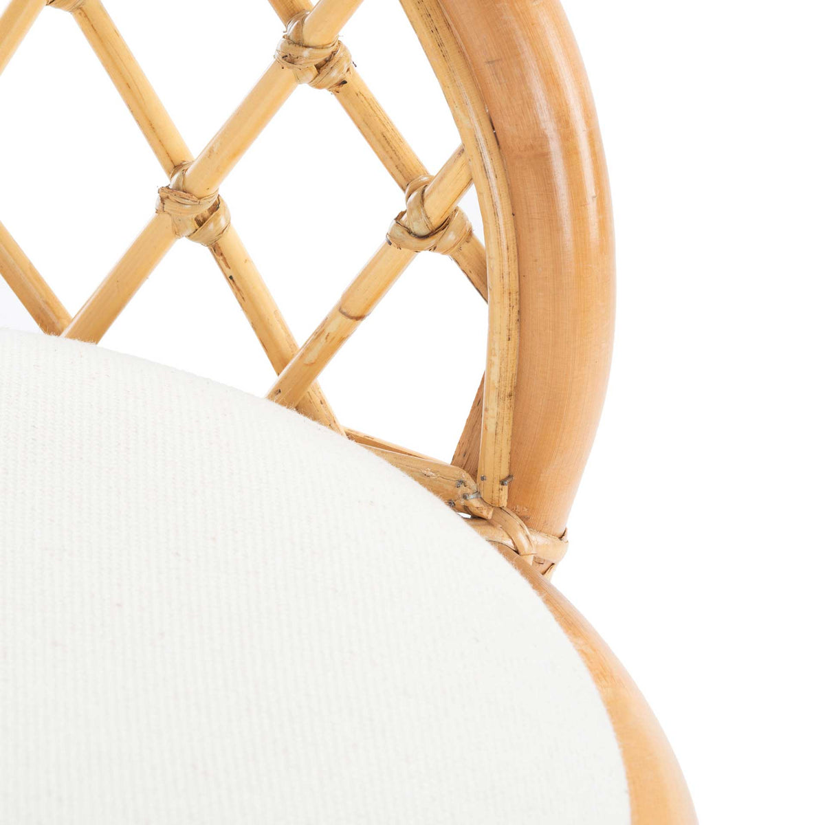 Intricate rattan lattice meets a smooth curved frame and softly textured white cushion