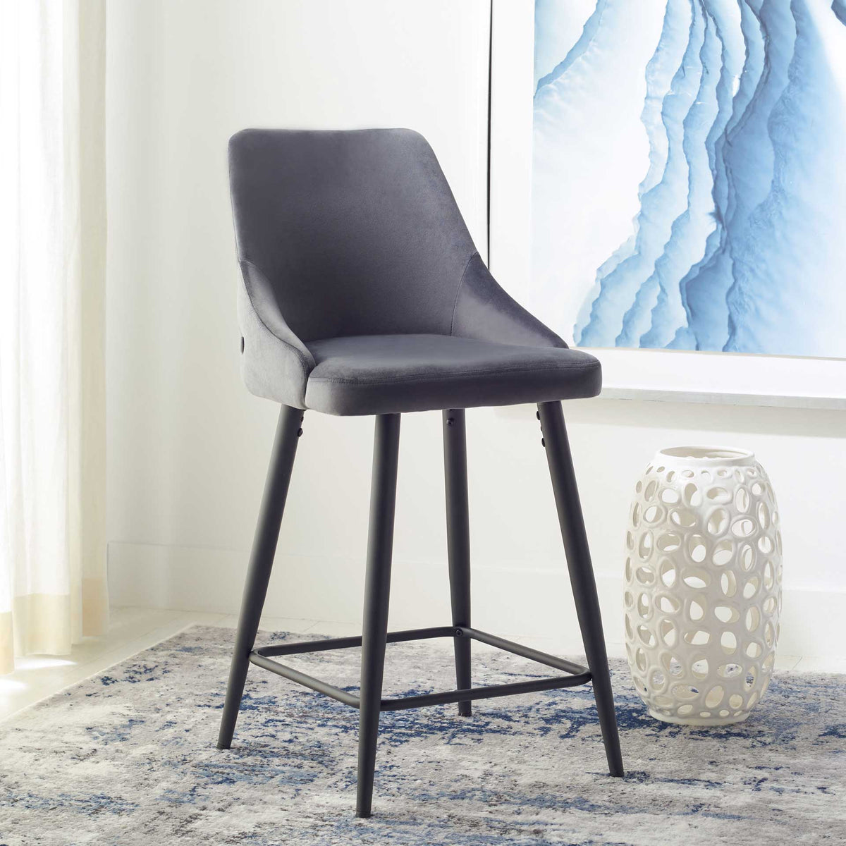 Shale velvet counter stool pairs a gently sculpted seat with a black metal frame and built-in footrests