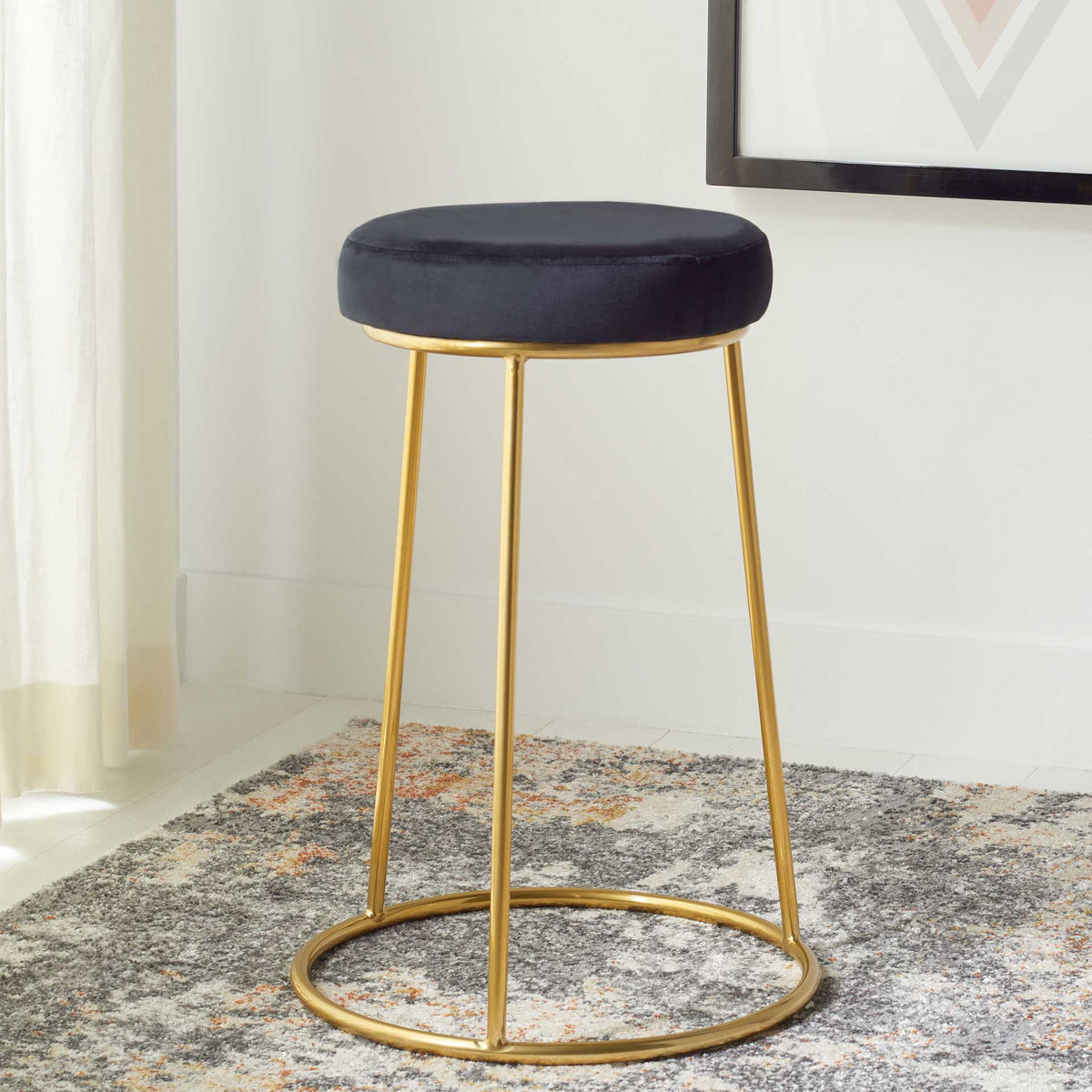 A black velvet seat and delicate gold frame bring understated glam to this backless counter stool.