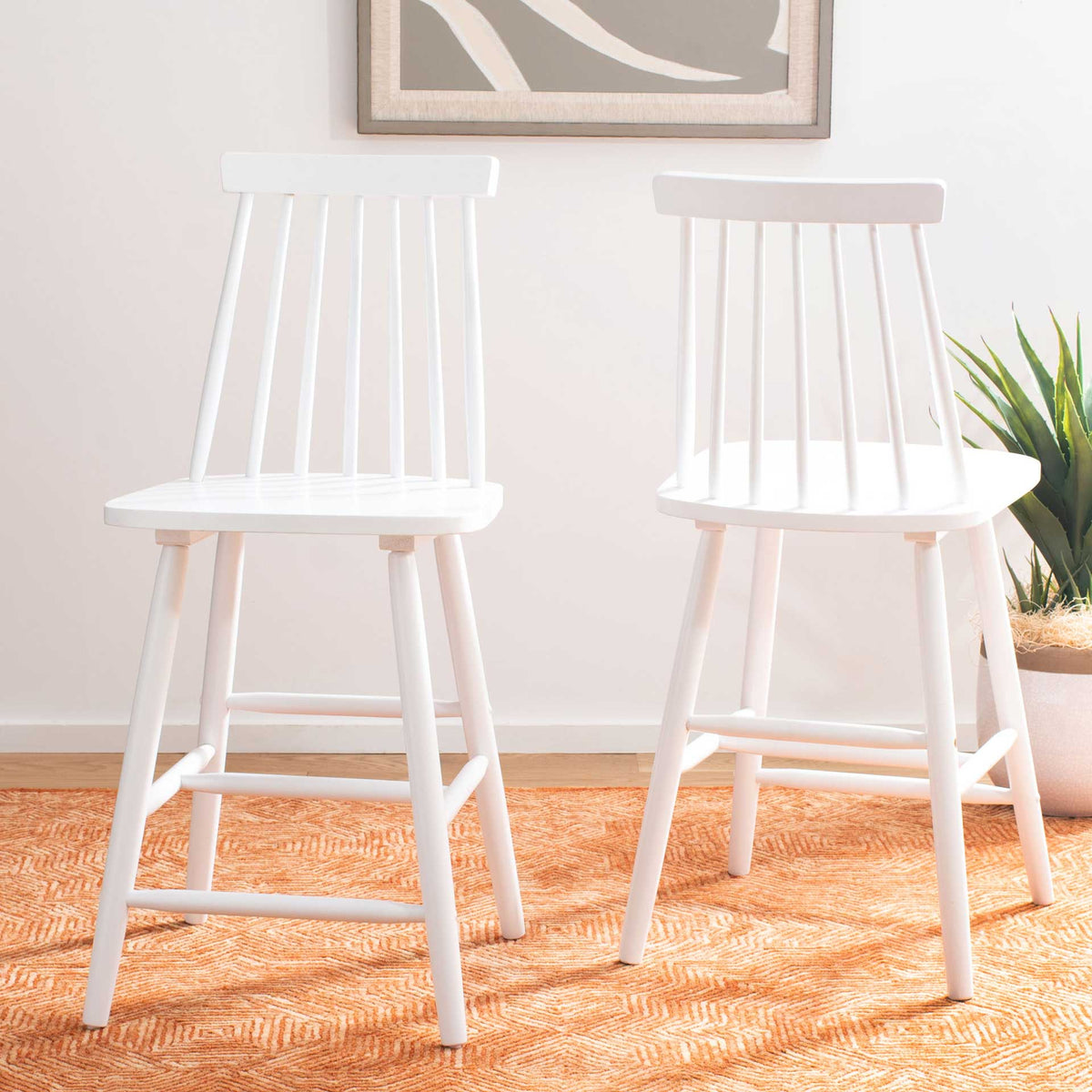 Two white counter stools brighten a room with open spindle backs and contoured seats.