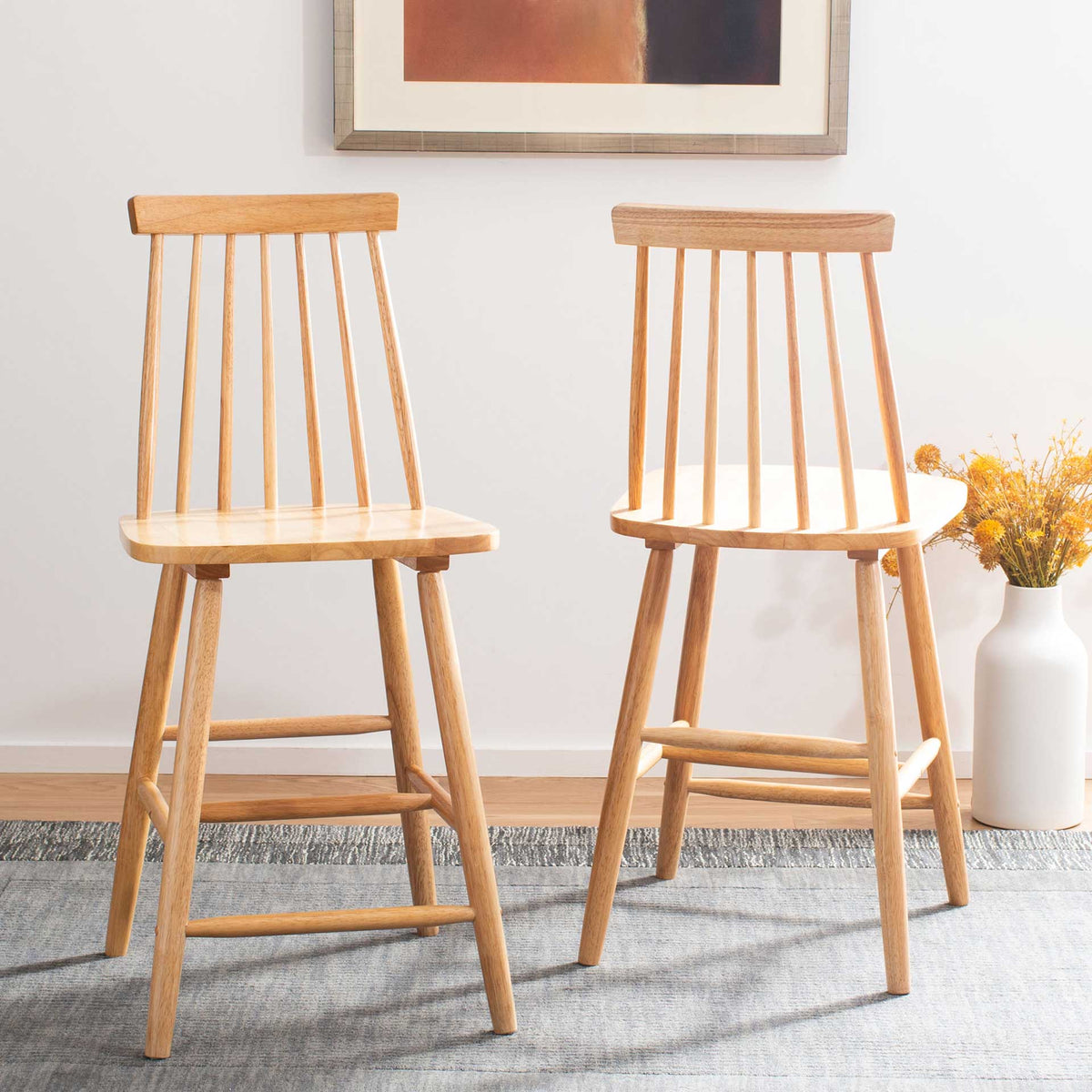 Two natural wood counter stools bring light grain and airy spindle backs to a sunny room.