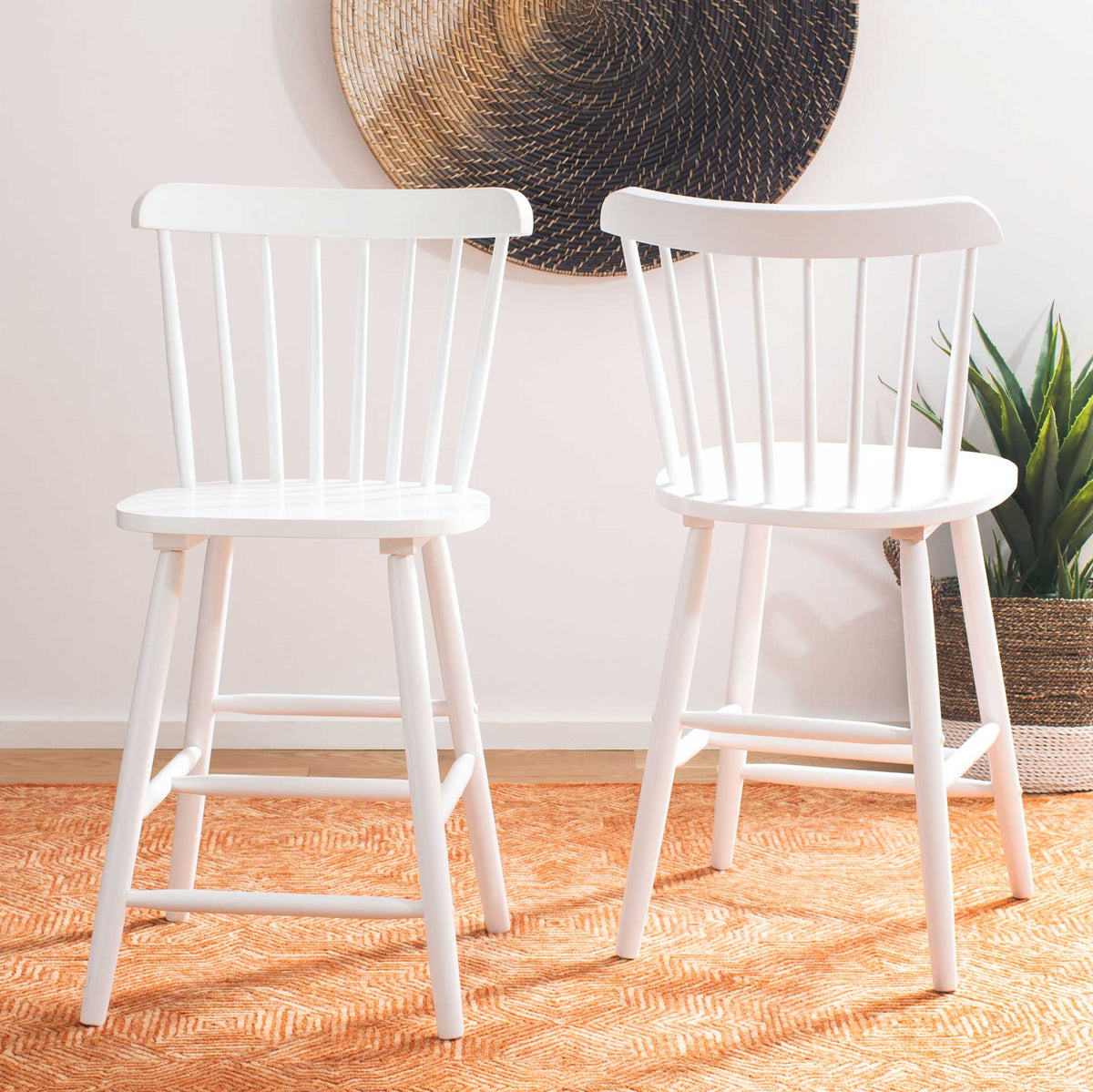 Two white counter stools add airy spindle backs and versatile seating to a warm room.