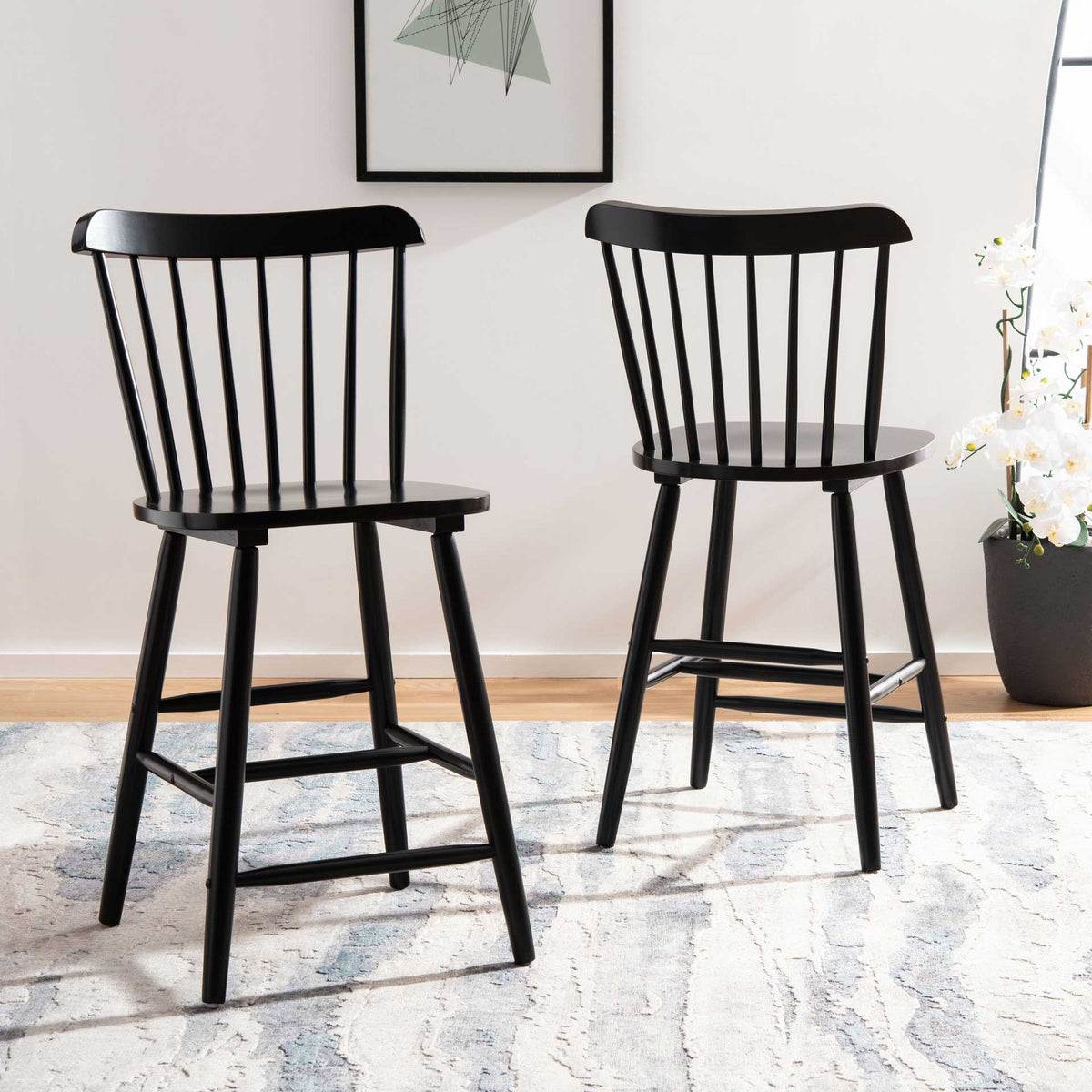 Two black counter stools bring classic spindle backs and sleek lines to a bright room.