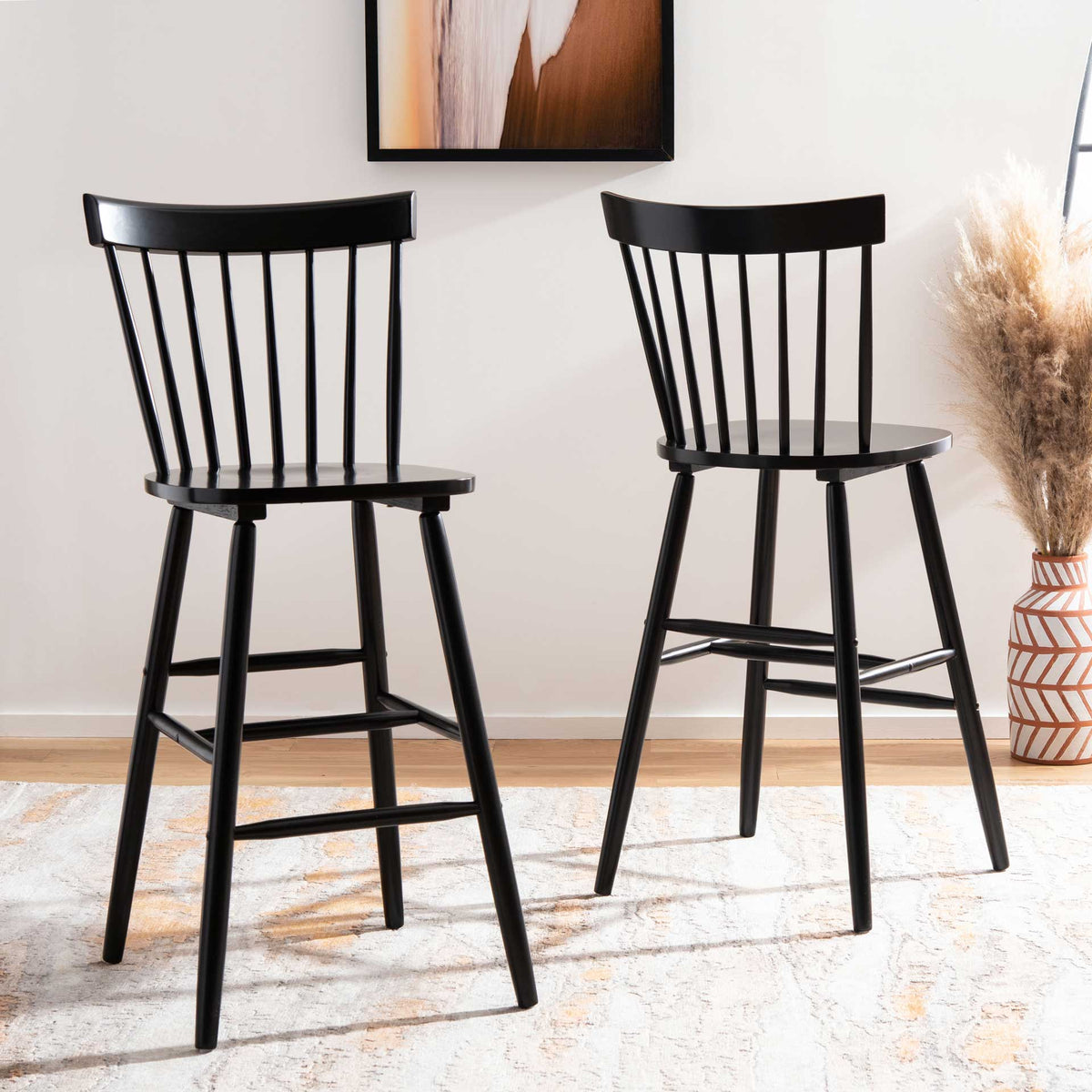 Two black spindle-back bar stools bring classic contrast and inviting seating to a room.