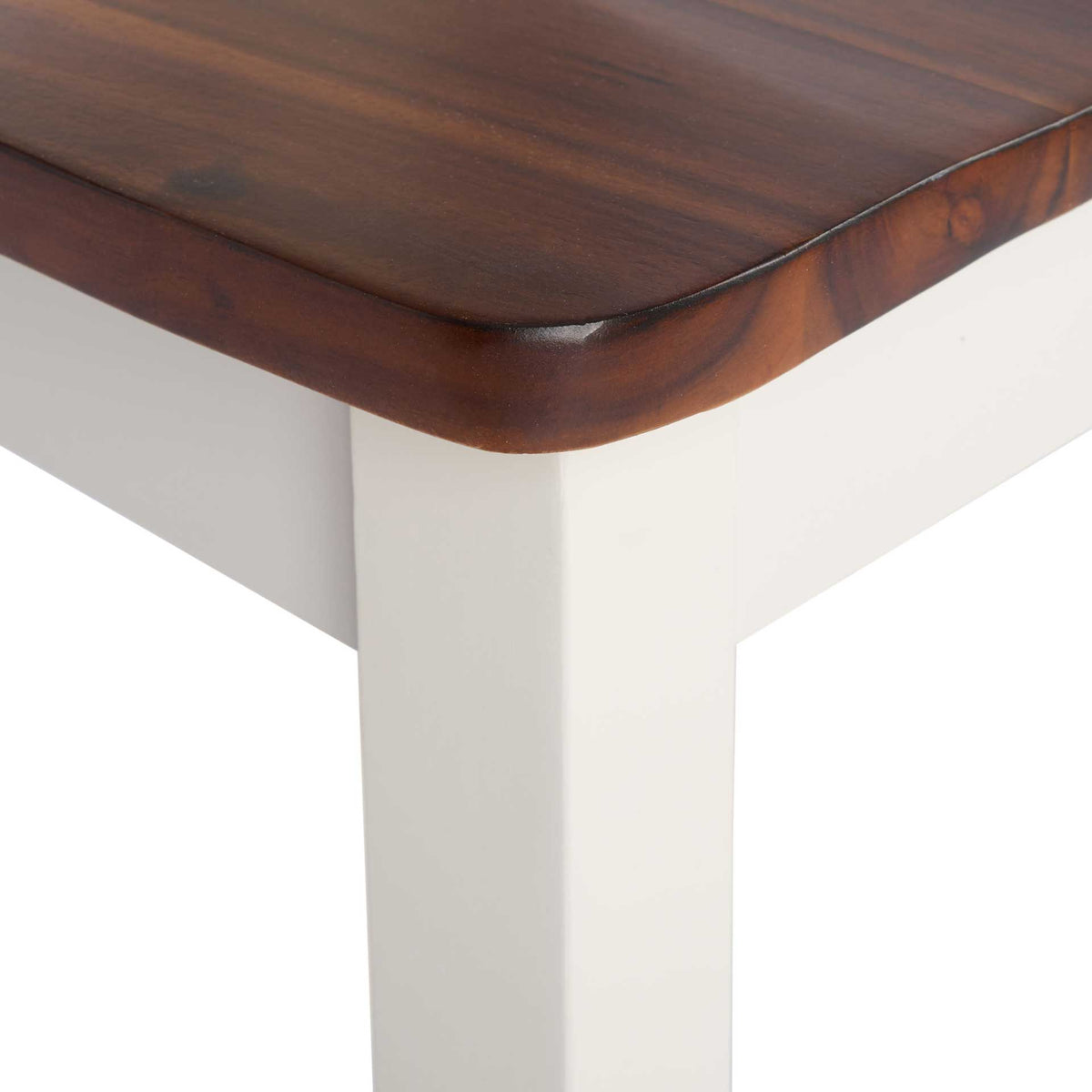 A softly rounded wood seat edge shows rich brown grain above the crisp white frame.