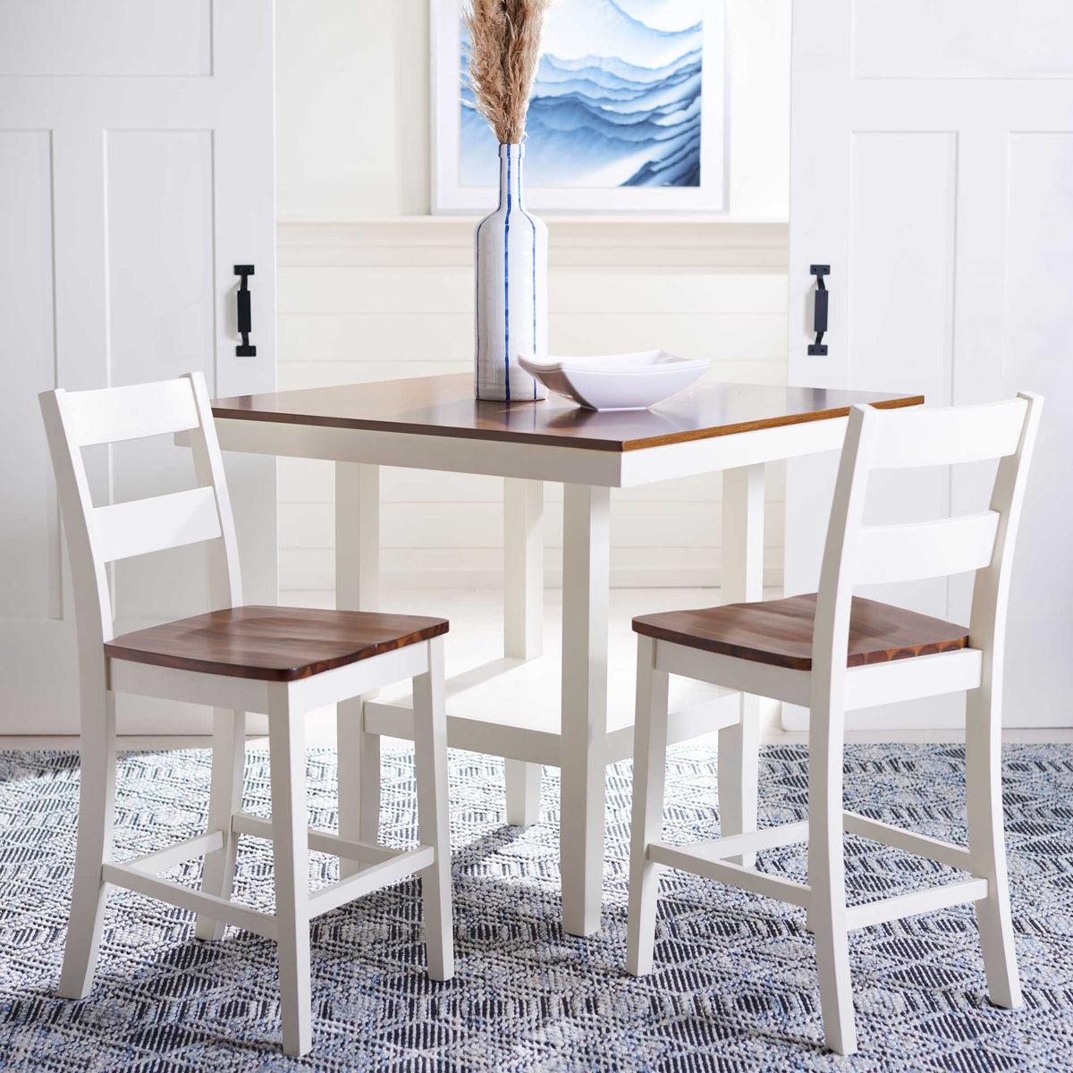 Two white ladder-back counter stools with brown wood seats bring warmth to the dining area.