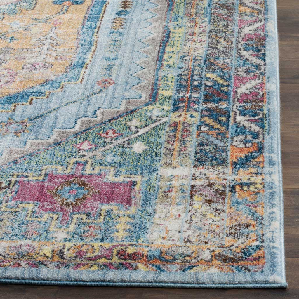 Layered blue, camel, and pink motifs meet at a neatly bound rug edge