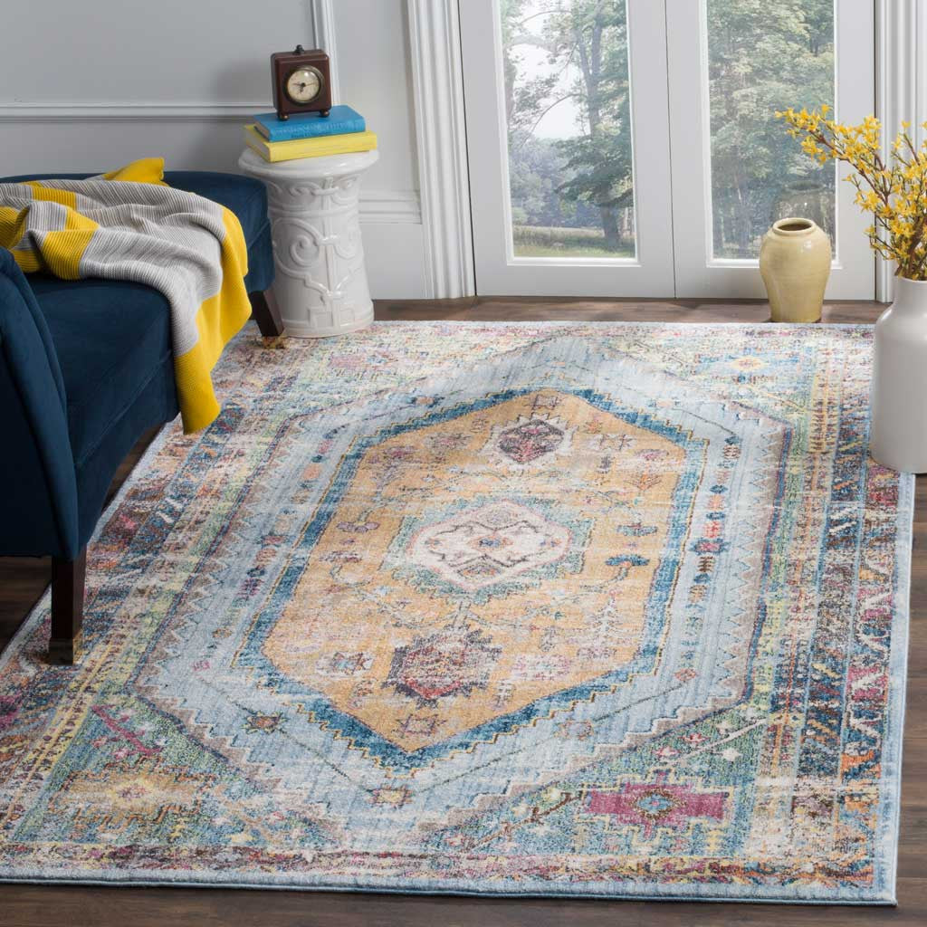 A distressed blue and camel medallion rug brings vintage-inspired color to a bright living room