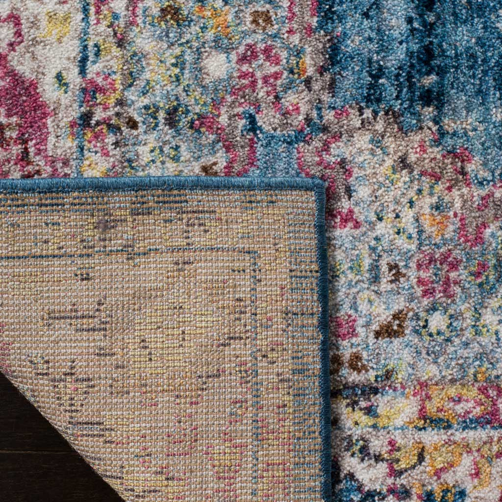 A woven jute backing and finished blue edge complement the rug's colorful floral pile