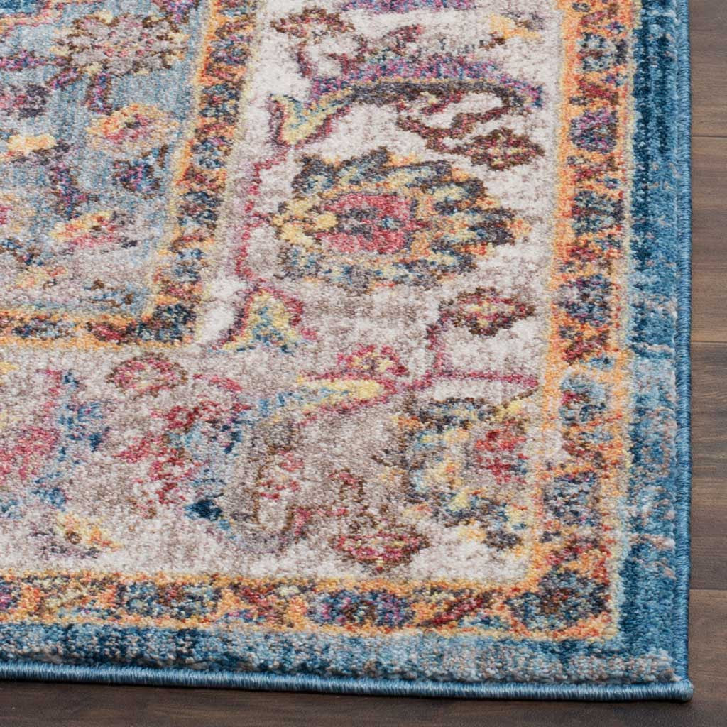 A neatly bound blue edge finishes a floral border layered with ivory, coral, and gold tones.