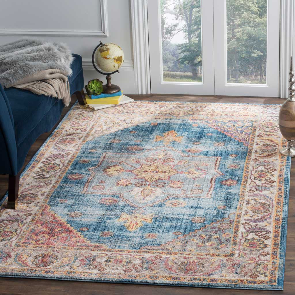 A distressed blue medallion rug adds vintage charm with an ivory floral border and warm coral accents.