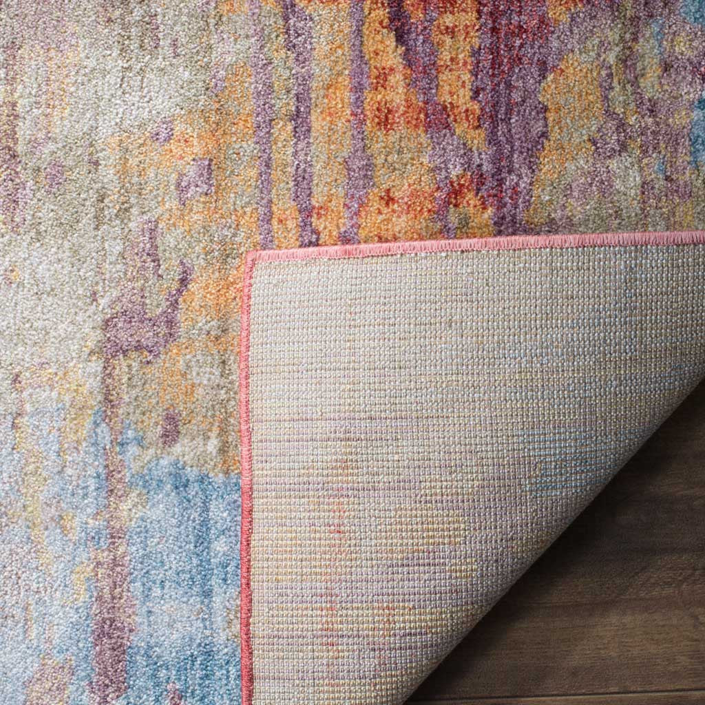 A folded corner reveals woven jute backing and pink edge binding beneath the colorful pile.