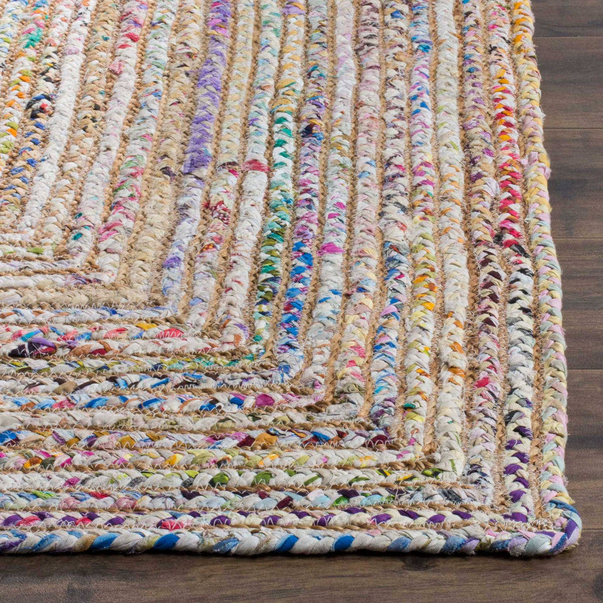 Chunky jute and cotton braids blend pink, blue and gold along a neatly finished rug edge