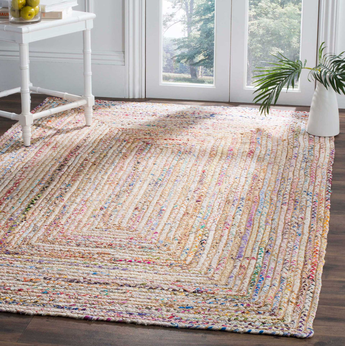 Colorful nested stripes add lively texture beneath furniture on a beige woven rug