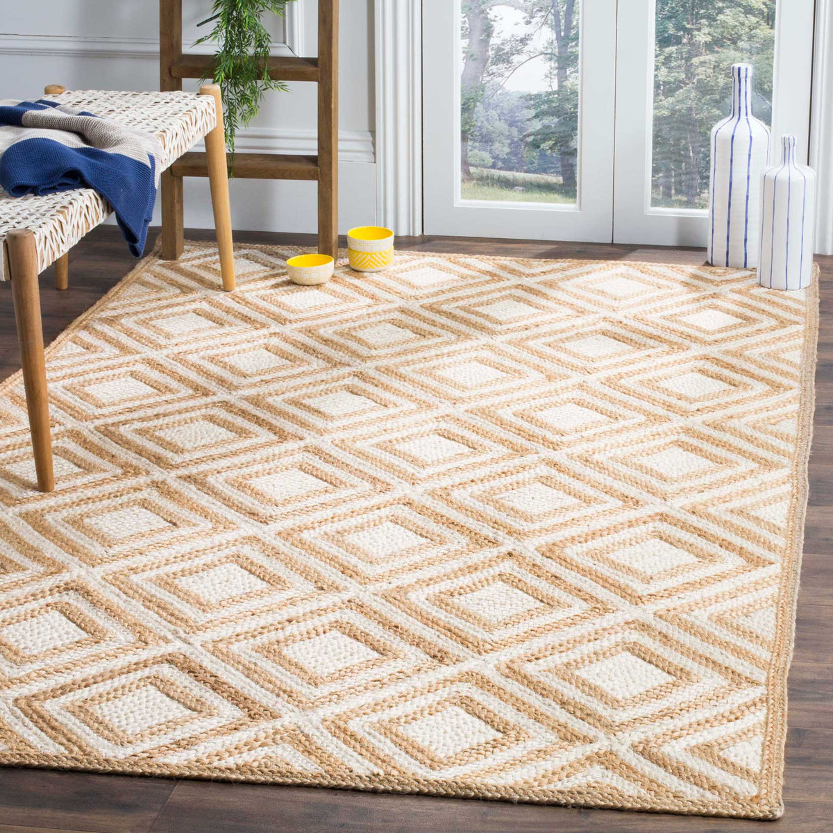 Ivory-and-tan diamond rug lends warm geometric rhythm beneath a woven bench