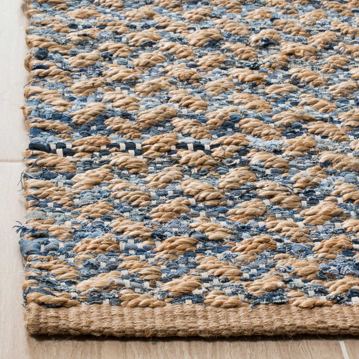 Raised tan jute loops mingle with blue fabric accents near a thick woven edge