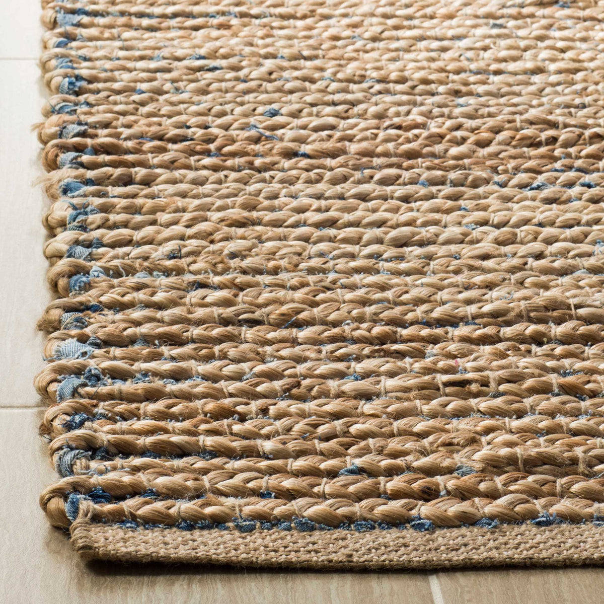 Thick jute loops reveal flecks of blue alongside a neatly bound edge