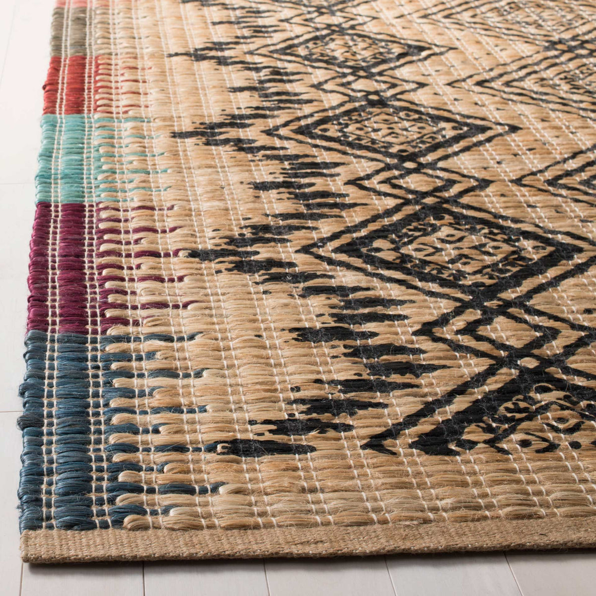 Black geometric lines cross textured tan fibers beside blue, red and green bands