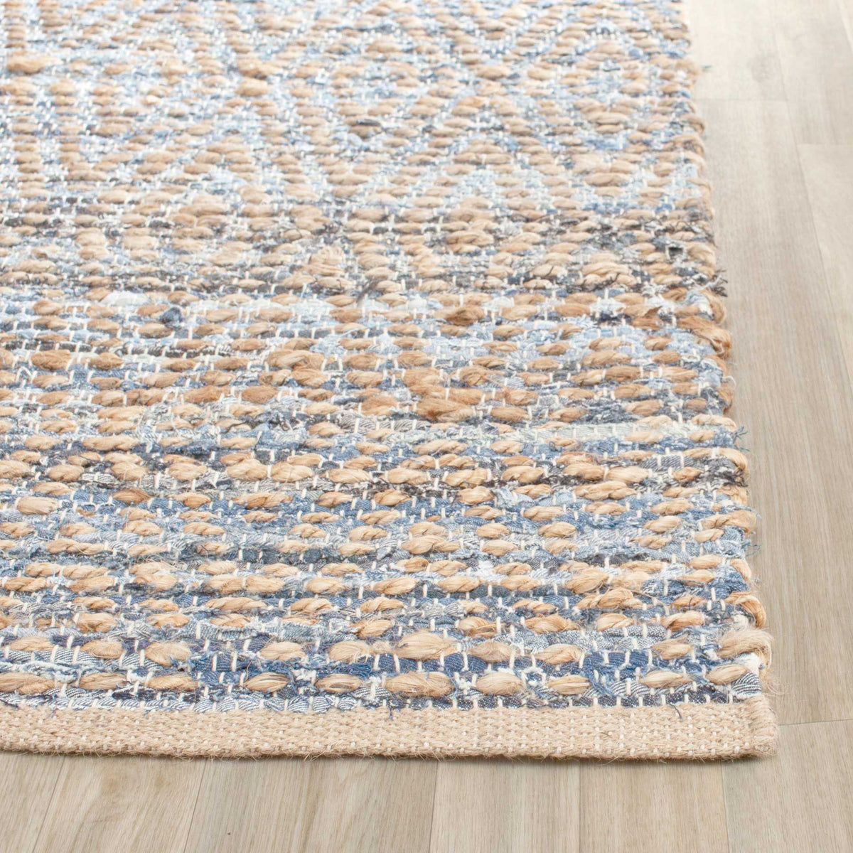 Denim-blue threads weave through chunky jute fibers beneath a neatly finished natural edge