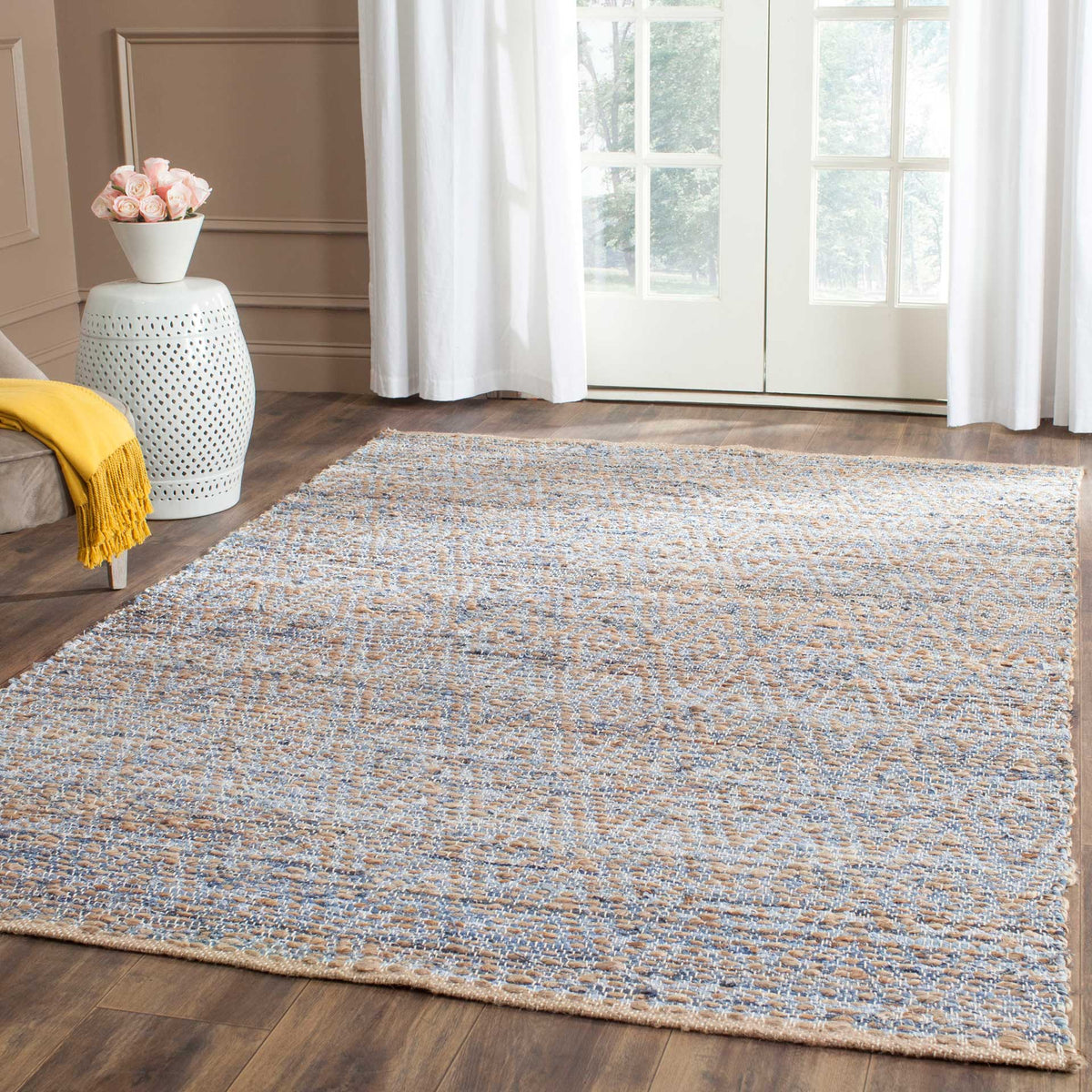 Soft blue flecks across a natural jute rug bring warmth to a relaxed space