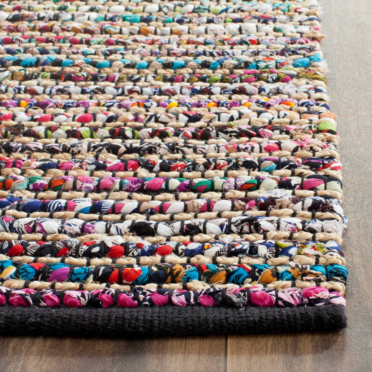 Bright pink, blue, and cream fabric strips create textured rows above a dark bound edge