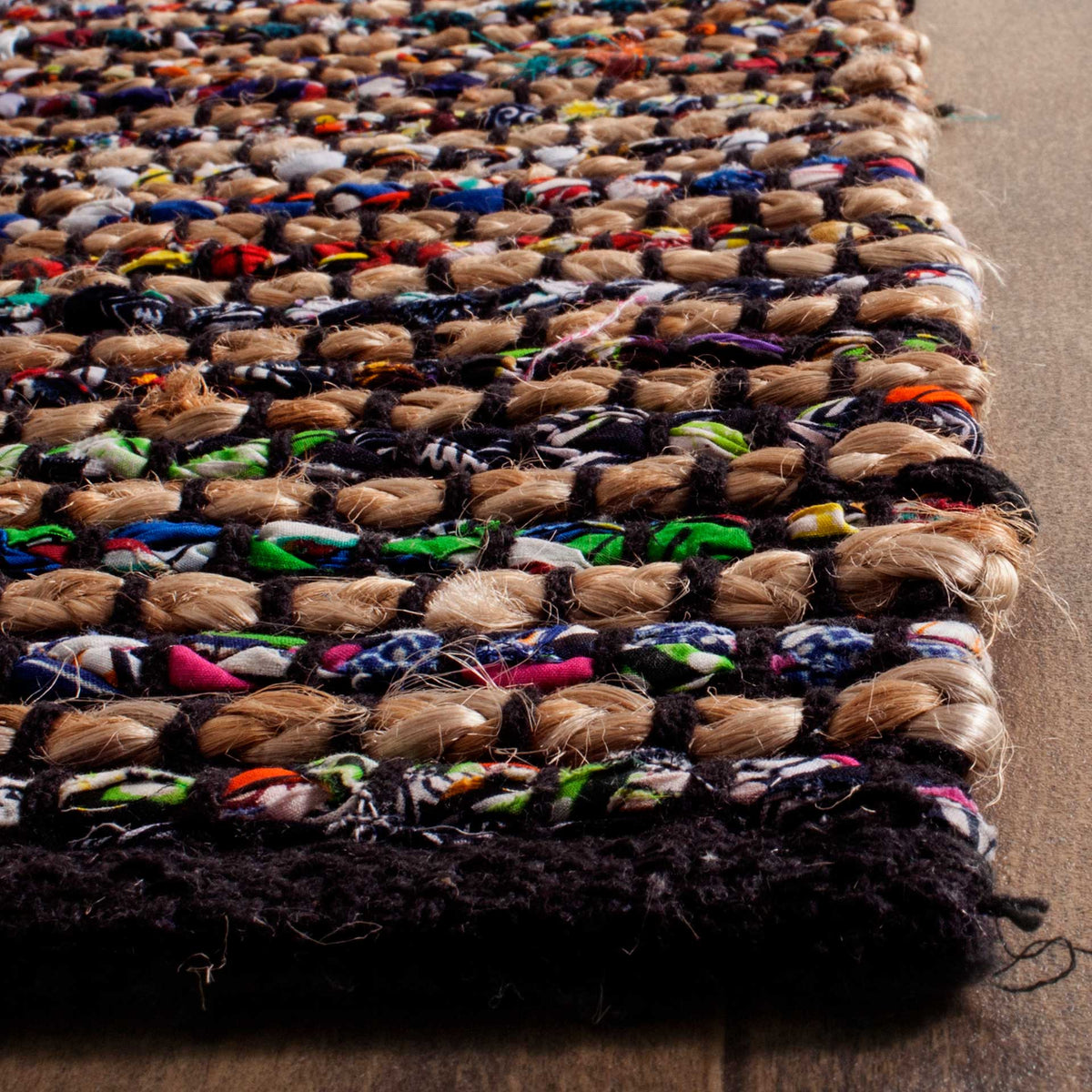 Chunky tan jute loops and bright fabric threads rise from a dark bound edge