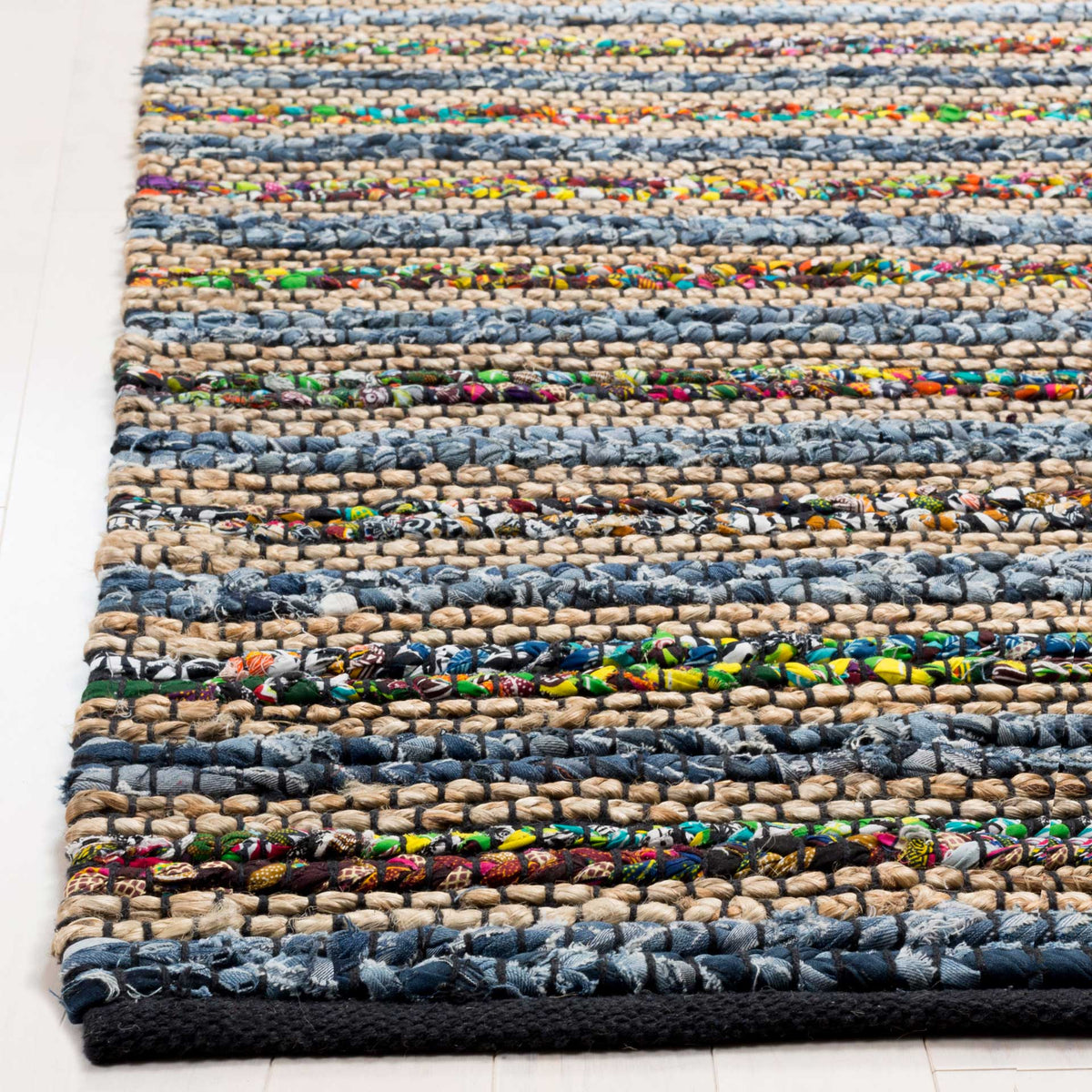 Colorful fabric knots punctuate chunky blue and tan rows above a dark woven border