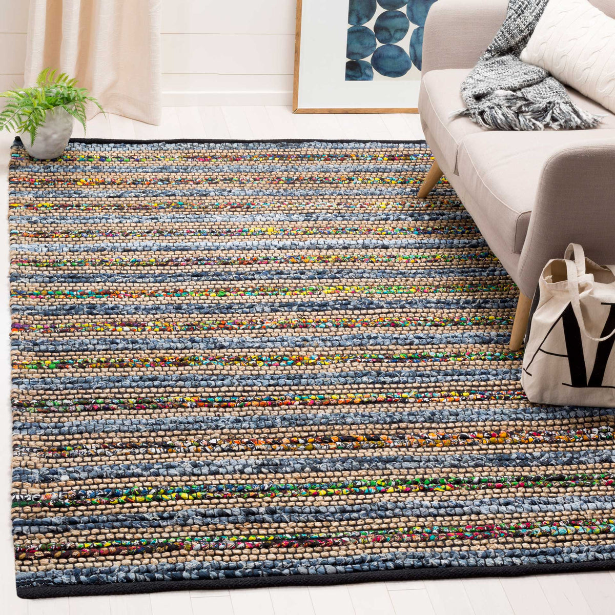 Blue striped rug adds playful multicolor texture beneath a neutral sofa