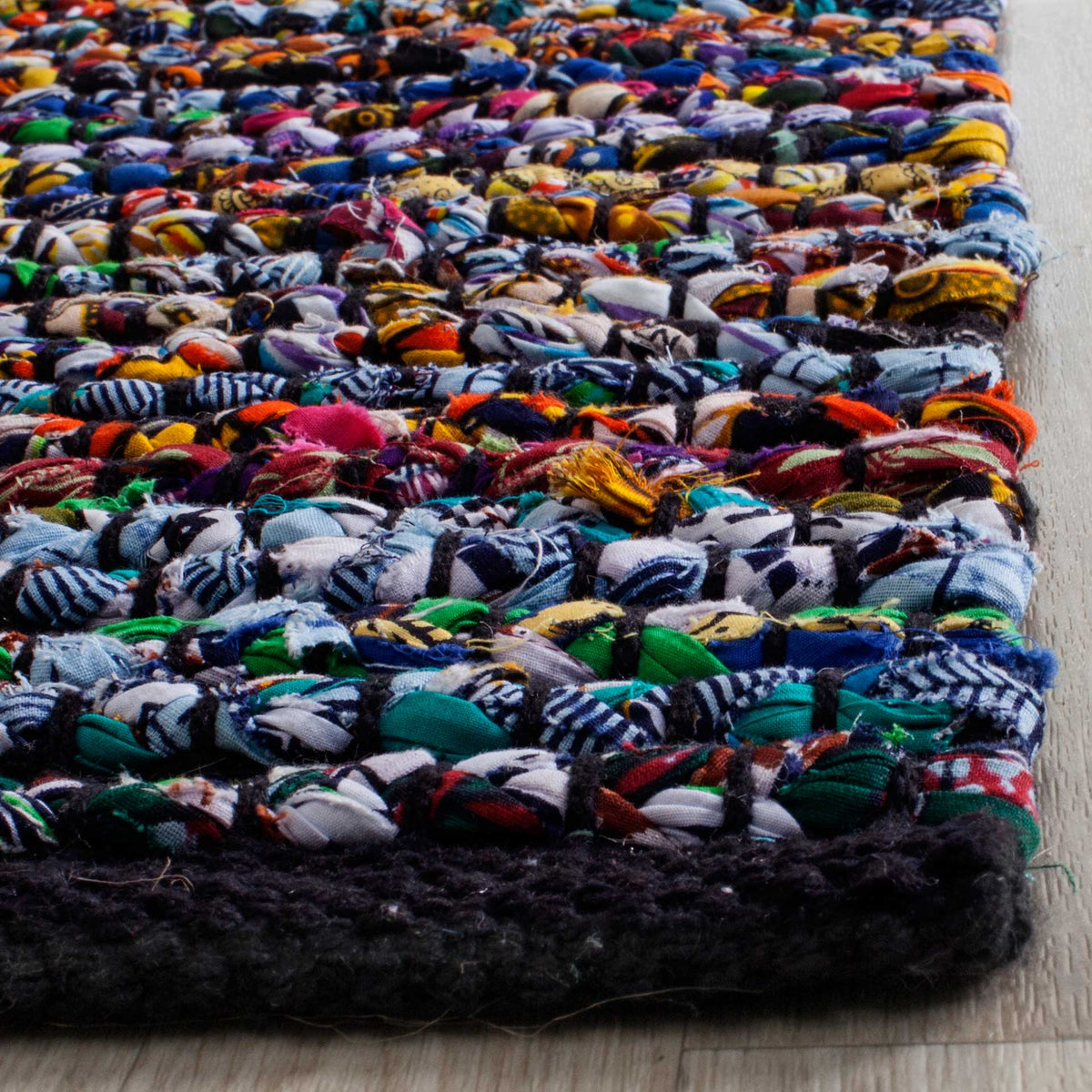 Vivid fabric strips form chunky rows above a deep charcoal woven edge