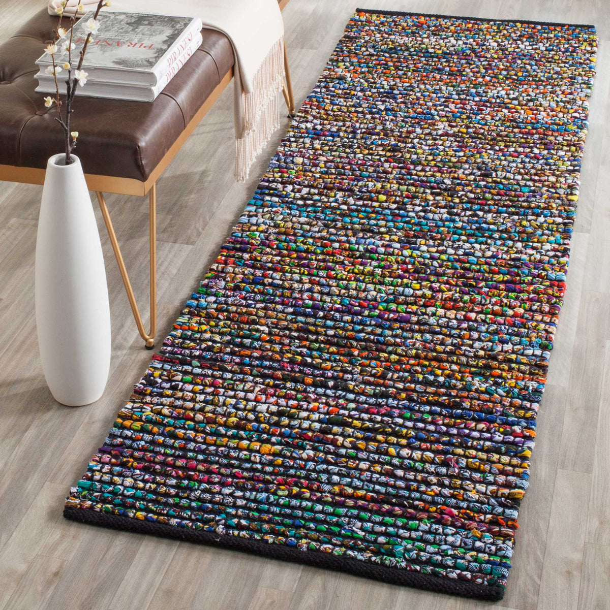 Bright rainbow colors energize this textured striped runner with dark edge trim