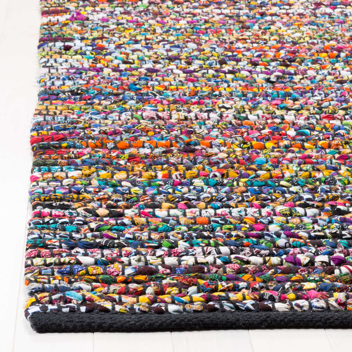 Braided rows of jewel-toned fabric bring dimension to a dark rug edge