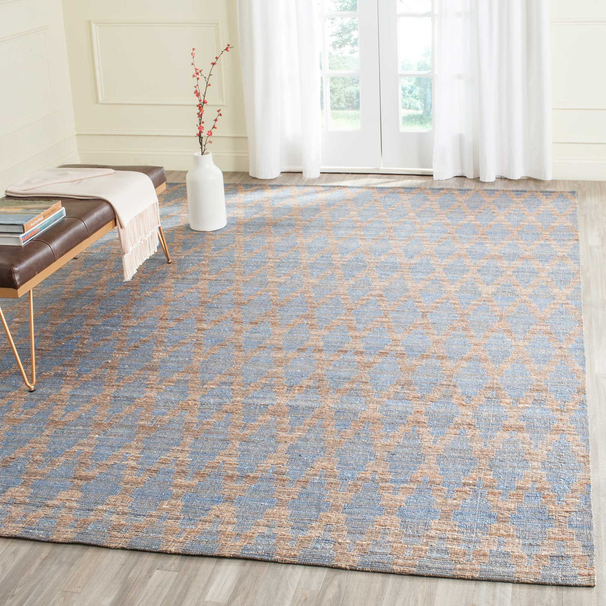 Light blue and gold patterned rug adds airy color beneath a low bench