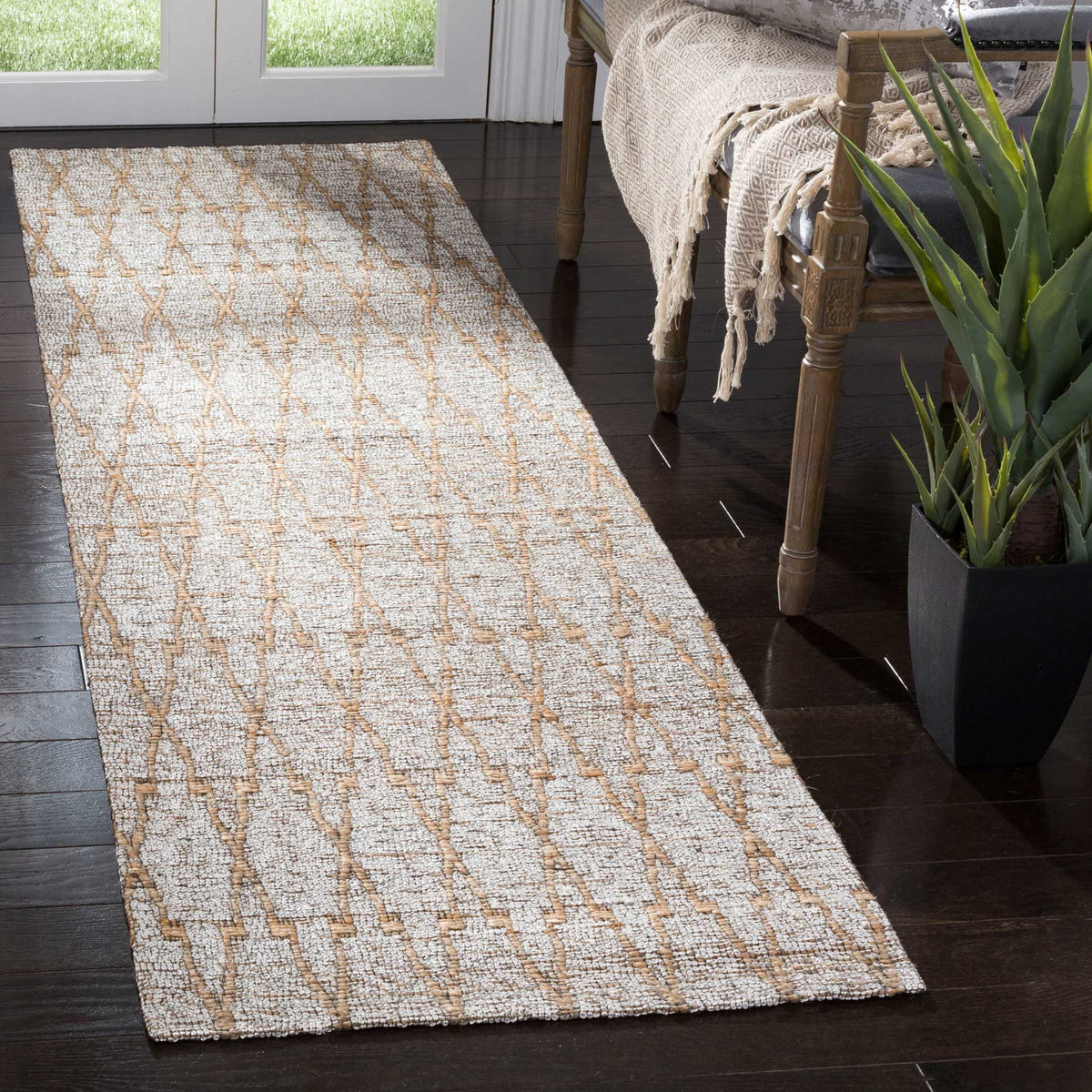 An interlocking natural-toned motif brings crisp contrast to the pale silver weave