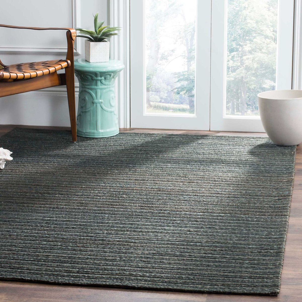 Deep green ribbed rug grounds seating with a quiet, natural texture
